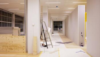 Image Of A Hallway With Offices On Both Sides, Currently In The Midst Of Renovation.